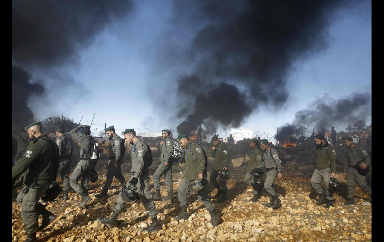 Policías israelíes se dirigen a evacuar a habitantes de una estructura construida ilegalmente en tierra privada palestina, donde se atrincheraron para evitar su demolición, en Elazar, Territorios Palestinos. AFP/M. Kahana