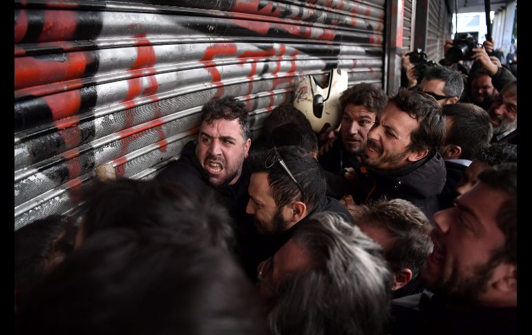 Integrantes de un sindicato intentan entrar al Ministerio del Trabajo griego en Atenas, durante una protesta en contra de la decisión del gobierno de reformar la ley sobre huelgas. AFP/A. Messinis