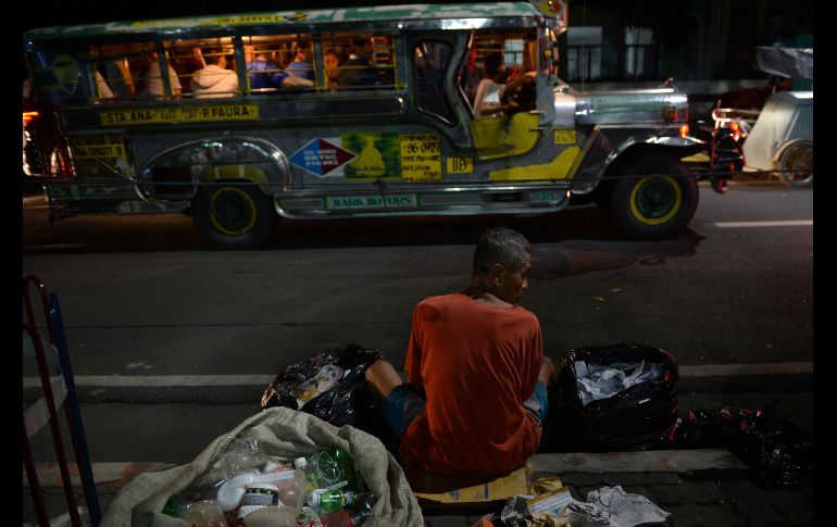 En un edificio de oficinas en Manila, Filipinas, se ve a un hombre mientras separa materiales reciclables, el cual gana unos cuatro dólares diarios por esta actividad. AFP/T. Aljibe