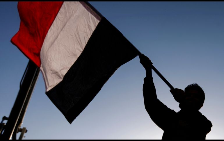 Un yemení ondea una bandera nacional en un acto en Saná para celebrar la muerte del ex presidente Ali Abdullah Saleh, un día después de que fue asesinado. AFP/M. Huwais