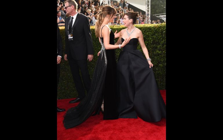 Dakota Johnson y Alison Brie se saludan.