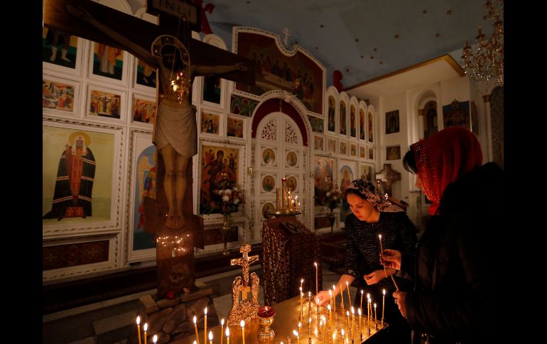 Devotos de la Iglesia Rusa Ortodoxa encienden velas durante la madrugada de la Pascual ortodoxa en Kirguistán. Los cristianos ortodoxos celebran la Pascua según el antiguo calendario juliano. EFE / I. Kovalenko