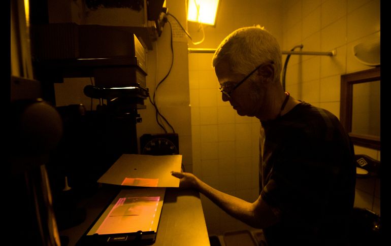 Con una cámara Olympus de hace medio siglo y una ampliadora de negativos que compró en 1980, el fotógrafo Rodrigo Benavides, de 58 años, revela fotos en el pequeño cuarto oscuro que improvisó en el baño de su casa en Caracas, Venezuela. AFP/F. Parra