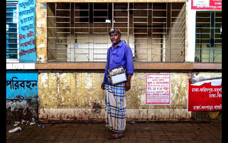 Mohammad Joynal, un limpiador de orejas, posa en una calle donde labora en Dacca, Bangladesh. Esta actividad icónica de la vida callejera de la ciudad está en decadencia ante la producción de hisopos de algodón baratos. AFP/M. Uz Zaman