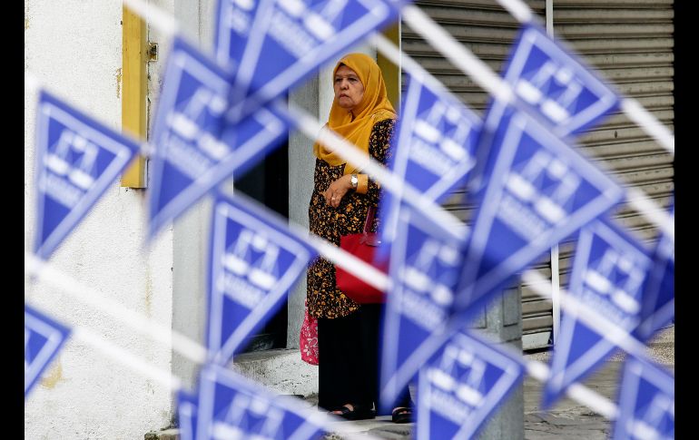 Una mujer se ve junto a banderas de propaganda de la coalición del Frente Nacional en Kuala Lumpur, Malasia. El 9 de marzo se realizan elecciones generales. AP/A. Favila