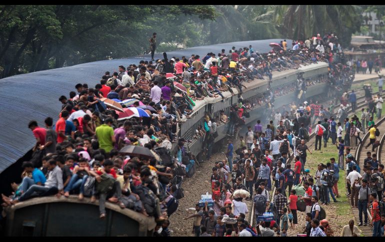 Musulmanes suben al techo de un tren sobresaturado en una estación de Dacca, Bangladesh. Cientos de miles viajan a sus casas para celebrar la 