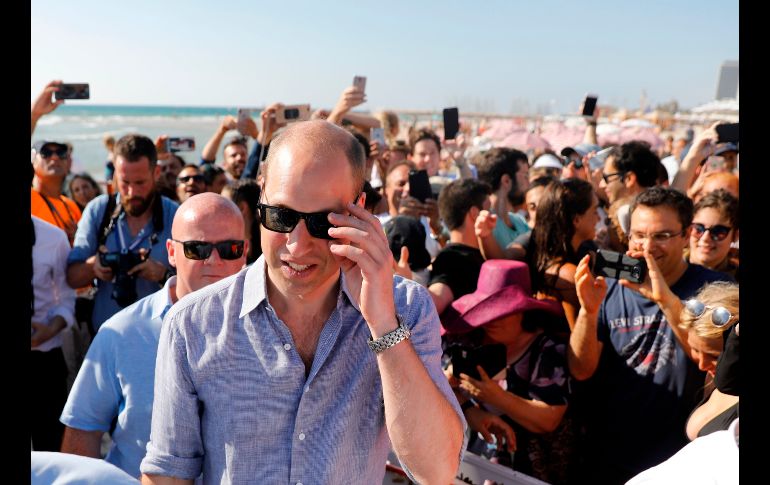 El príncipe Guillermo de Inglaterra (c) visita una playa de Tel Aviv, Israel. El segundo en la línea de sucesión a la corona británica empezó ayer un viaje por Jordania, Israel y los territorios palestinos, destinado a fomentar los vínculos británicos con la región. AFP/M. Kahana