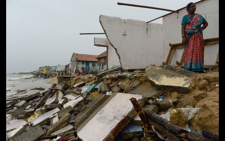 Una habitante se ve junto a su casa dañada en la costa de Chennai, India. Más de 50 viviendas resultaron afectadas por una marea alta acompañada por fuertes vientos. AFP/A. Sankar