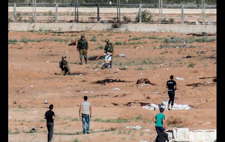 Soldados israelíes arrastran a un palestino herido que intentó acercarse a la reja fronteriza en Jabalia, en la Franja de Gaza. AFP/S. Khatib