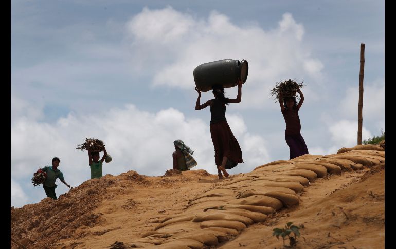 Jóvenes rohinyá llevan leña hacia el campamento de refugiados Kutupalong, en Bangladesh. AP/W. Maye-E