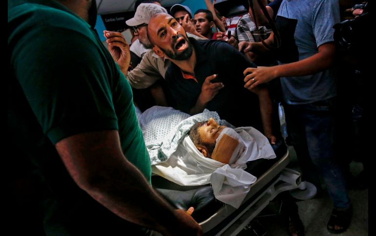 Familiares de Abdel Karim Radwan reaccionan junto a su cuerpo en un hospital de Khan Yunis, en la Franja de Gaza. El hombre murió por un ataque aéreo israelí. AFP/S. Khatib