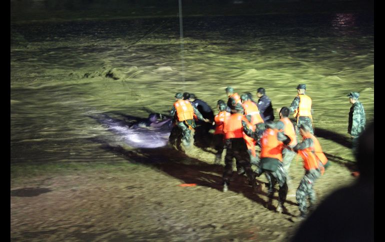 Policías rescatan a un hombre de una zona inundada en Linxia, China, tras fuertes lluvias que han dejado al menos ocho muertos. AFP