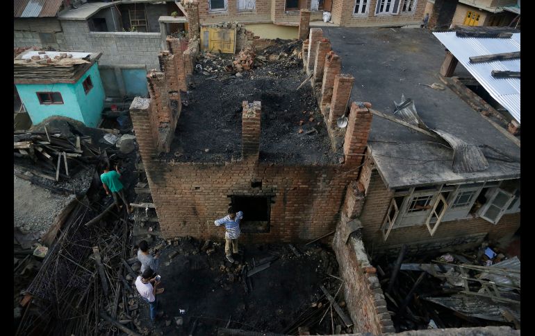 Cachemires inspeccionen casas dañadas en un combate entre soldados indios y presuntos militantes en Redwani, en la disputada Cachemira bajo control de la India. AP/M. Khan