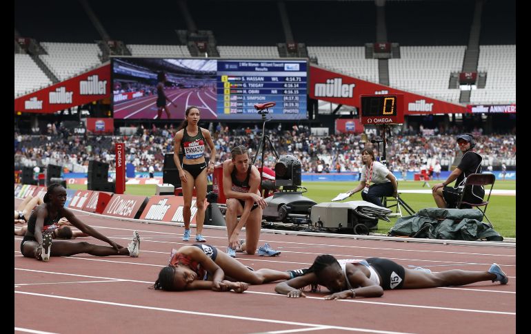 Atletas colapsan tras cruzar la meta en la carrera de una milla, en el marco de los juegos de aniversario en el estadio Reina Isabel de Londres, Inglaterra. AFP/I. Kington