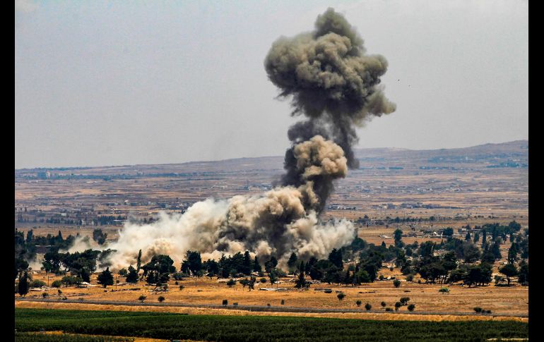 Una columna de humo se ve en la zona de Quneitra, Siria, captada desde la zona fronteriza de los Altos del Golán. Rebeldes sirios destruían sus reservas de armas antes de evacuar la provincia tras un acuerdo de rendición. AFP/J. Marey