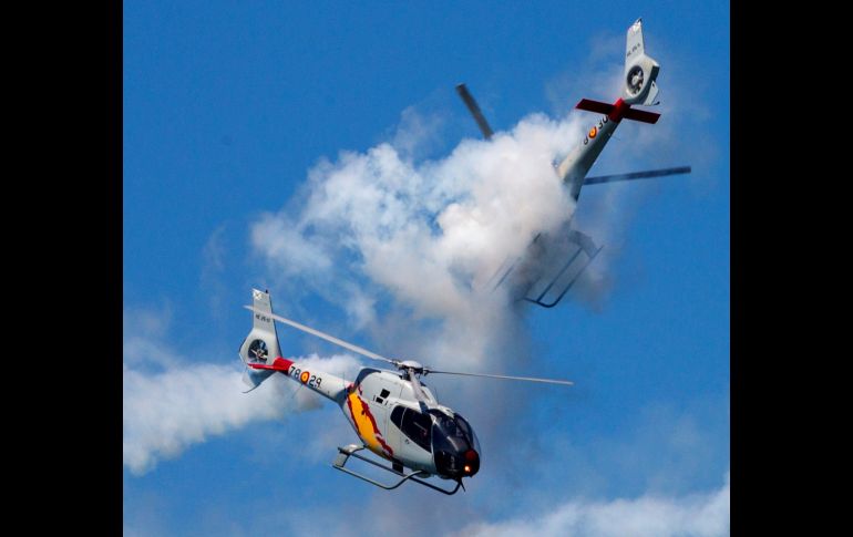 Integrantes de la patrulla acrobática ASPA del Ejército del Aire se ven en un cruce que deja mínimos espacios entre sus hélices, durante la decimotercera edición del Festival Aéreo de Gijón, España, en el que participan una treintena de aviones y helicóptero. EFE/ A. Morante