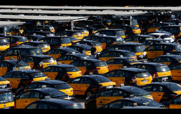 Un chofer camina entre taxis estacionados en el aeropuerto de Barcelona en Prat Llobregat, España, durante una huelga de taxistas de 48 horas en protesta por el creciente uso de los servicios vía aplicaciones, como Uber y Cabify. AP/M. Fernández