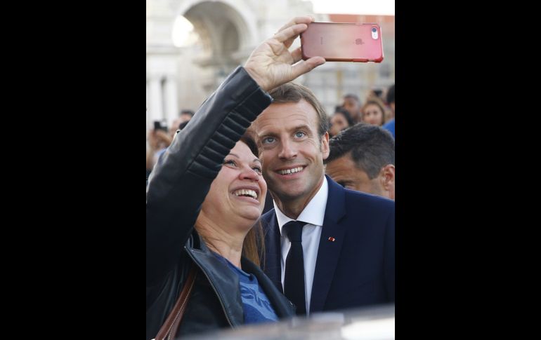 El presidente francés Emmanuel Macron posa para una foto durante el paseo por la plaza del Comercio de Lisboa, Portugal, tras su visita a la Agencia Europea de Seguridad Marítima, en el marco de la cumbre de interconexiones energéticas. EFE/J.P. Gandul