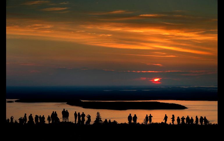 Un grupo de madrugadores se reúne cerca del pico de la montaña Cadillac en Bar Harbor, en Maine, para ver el amanecer. AP/R. Bukaty