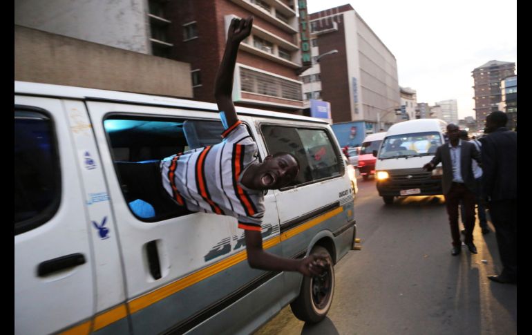 Un simpatizante del principal partido opositor celebra afuera de las instalaciones del instituto en Harare, Zimbabue. El líder opositor de Zimbabwe, Nelson Chamisa, proclamó hoy su victoria en las elecciones generales del lunes aunque aún no se dan los resultados oficiales. AP/T. Mukwazhi