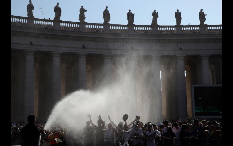 Un bombero refresca a los fieles que aguardan al Papa Francisco en la plaza de San Pedro, en el Vaticano. AP/A. Tarantino