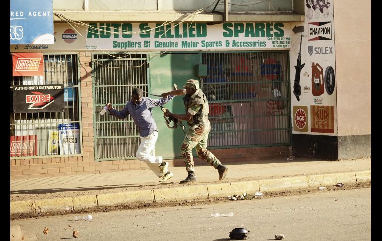 Un soldado golpea a un hombre en Harare, Zimbabue, durante protestas por un presunto fraude en las elecciones. Al menos un hombre murió luego de que el Ejército abrió fuego contra manifestantes. AFP/Z. Auntony