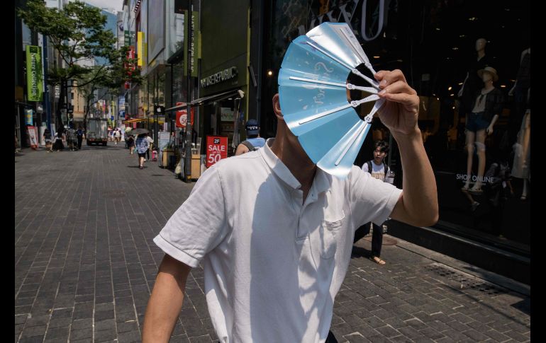 Un hombre se tapa del Sol en el distrito de compras de Myeongdong en Seúl, Corea del Sur. La capital registró 39 grados, la más alta temperatura para un 1 de agosto en 111 años. AFP/E. Jones