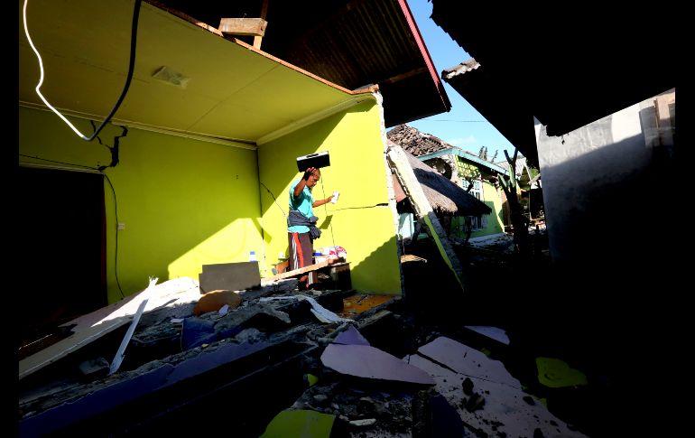 Un habitante rescata algunas pertenencias de una vivienda en Lombok Norte. El terremoto provocó una alerta de tsunami y atemorizó a residentes, que abandonaron sus casas para ponerse a salvo en tierras más altas,