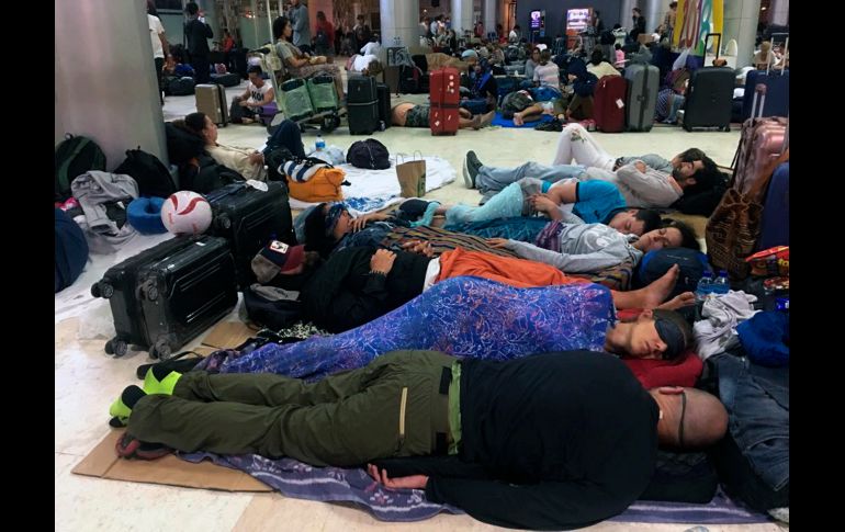 Viajeros duermen en el aeropuerto de Lombok.