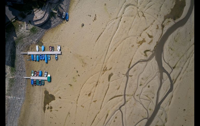 Botes se ven en el lecho seco del lago Brenet, parte del río Doubs, en Les Brenets, Suiza. Corriente arriba, el río se ha secado a pesar de las lluvias, debido a fallas geológicas.  AFP/F. Coffrini