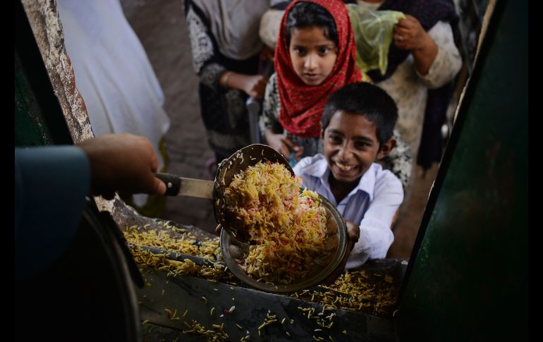 Niños reciben comida donada en un templo en Islamabad, Pakistán. AFP/A. Qureshi