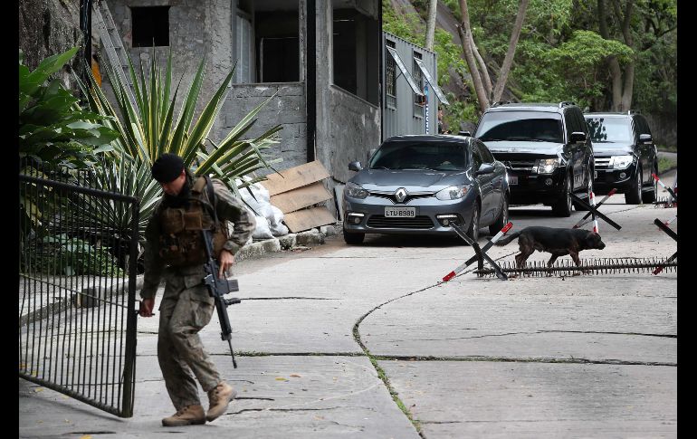 Un policía militar del Batallón de Operaciones Especiales abre el portón para dar paso a la comitiva del candidato a la presidencia de Brasil Jair Bolsonaro, tras visitar el cuartel general del BOPE en Río de Janeiro. EFE/M. Sayao