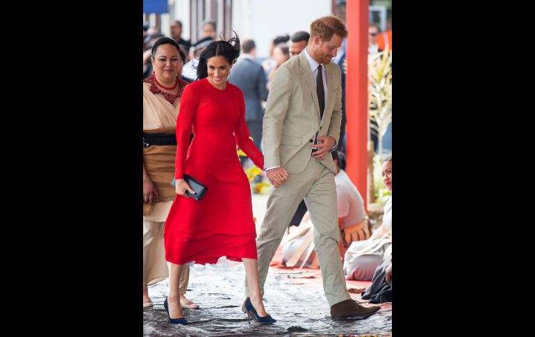 Una etiqueta cuelga del vestido de Meghan, esposa del príncipe Enrique de Inglaterra (d), a su llegada al aeropuerto Fua'amotu de Tonga. La pareja real realiza una gira oficial de 6 días a Australia y el Pacífico Sur. AFP/D. Lipinski