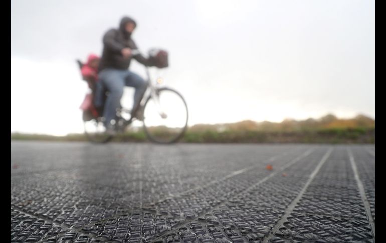 Un hombre monta en bicicleta por el primer carril para bicicletas solar en Erftstadt, Alemania. Los 90 metros de este carril cuentan con un módulo solar o fotovoltaico que produce electricidad. EFE/F. Vogel