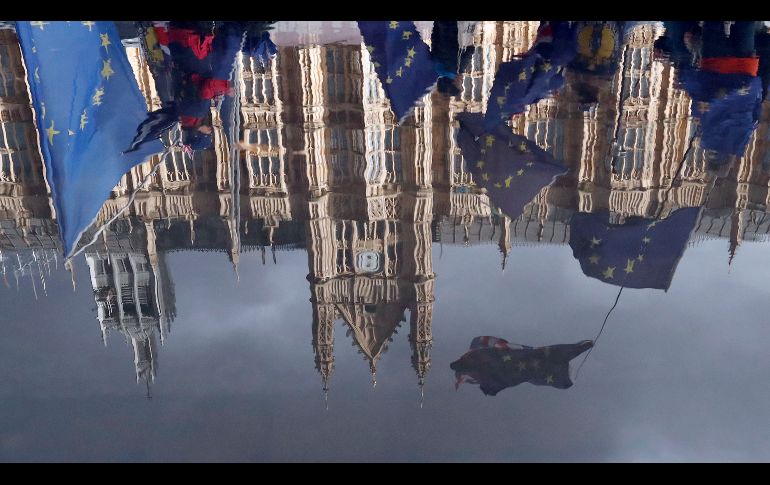 Manifestantes se reflejan en un charco frente al Parlamento en Londres, Inglaterra. La protesta es contra el 