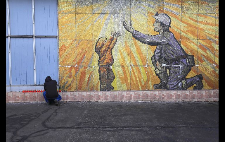 Un hombre prende una vela en un memorial improvisado en la mina de Stonava, en República Checa, un día después de la muerte de 13 mineros por un incendio en la mina de Karvina. AFP/R. Mica