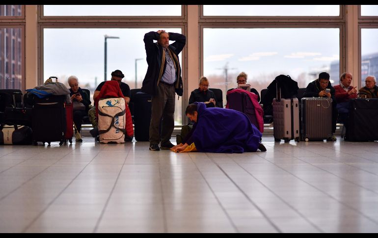 Viajeros aguardan en una terminal del aeropuerto de Gatwick, en el sur de Londres, luego de que comenzaron a despegar los vuelos tras un cierre de 36 horas debido a la presencia de drones. AFP/B. Stansall