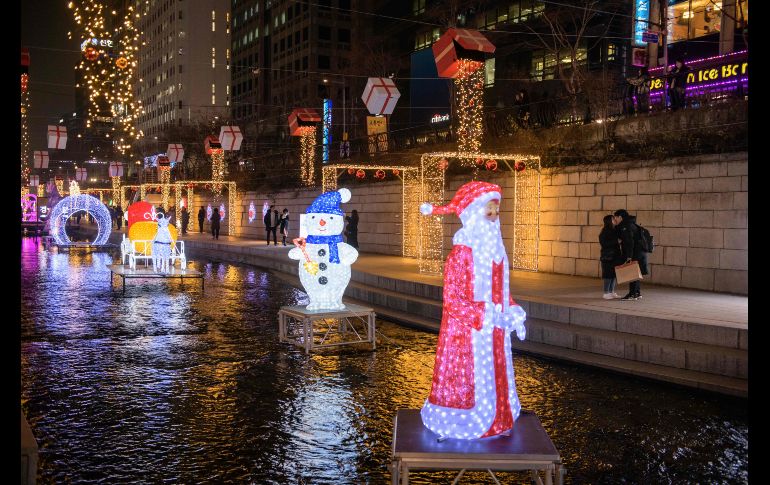 Una pareja se besa junto a adornos navideños en el centro de Seúl, Corea del Sur. AFP/E. Jones