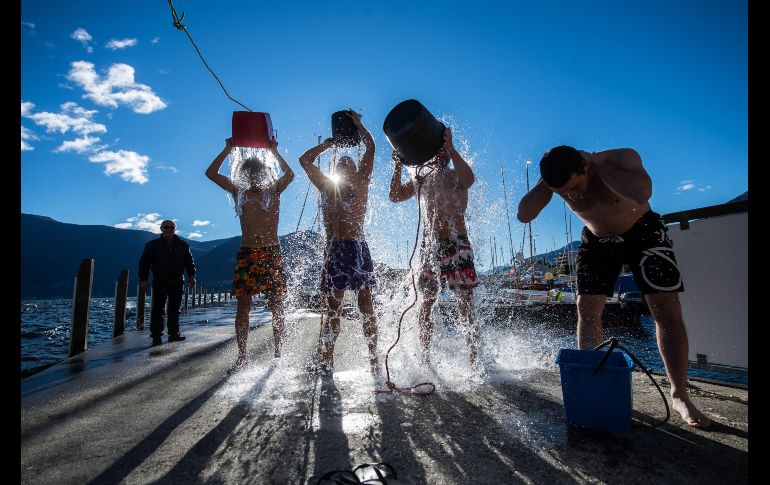 Un grupo de hombres participa en el tradicional baño de Epifanía en Brissago, Suiza, que consiste en recorrer 80 metros de distancia en el Lago Maggiore. EFE/S. Golay