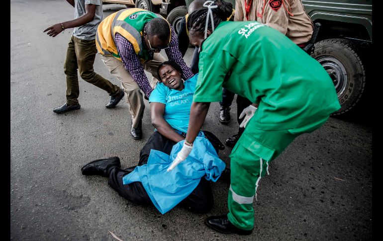 Una mujer colapsa al huir del sitio de una explosión en un complejo hotelero en Nairobi, Kenia. La Policía cree que el ataque es un acto terrorista. AFP/L. Tato