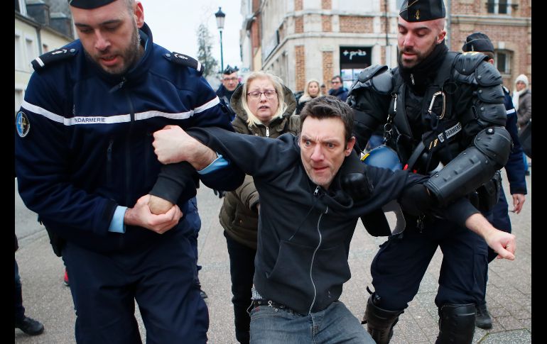 Policías detienen a un manifestante en el día en que el presidente francés Emmanuel Macron  visita la ciudad de Grand Bourgtheroulde, Francia. AP/F. Mori