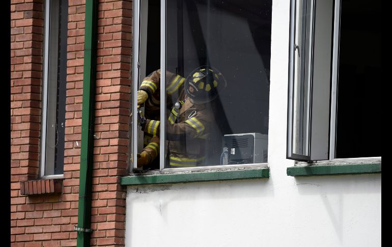 Bomberos retiran cristales rotos debido al estallido.