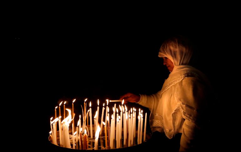 Una cristiana enciende una vela en el templo del Santo Sepulcro en la Ciudad Vieja de Jerusalén. AFP/T. Coex