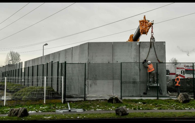 Trabajadores colocan bloques de concreto para levantar un muro de tres metros de altura en una estación de la empresa Total en Calais, Francia, para evitar que migrantes se suban a camiones estacionados en el sitio. AFP/P. Huguen