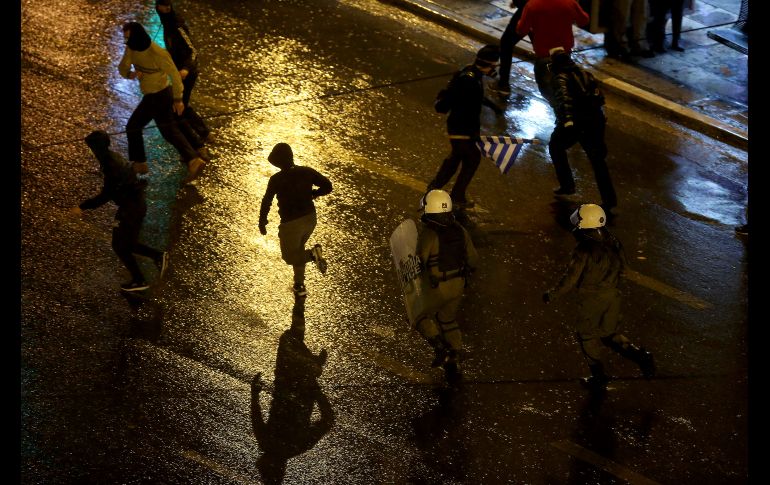 Policías persiguen a manifestantes afuera del Parlamento en Atenas, Grecia. Los legisladores debaten un histórico acuerdo que busca regularizar las relaciones con Macedonia. AP/P. Giannakouris