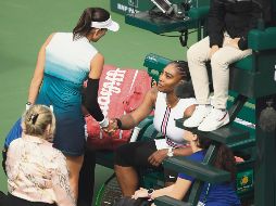 Garbiñe Muguruza se acerca a Serena Williams luego de que la estadounidense dejara su duelo apenas al inicio del segundo set. AFP / C. Brunskill