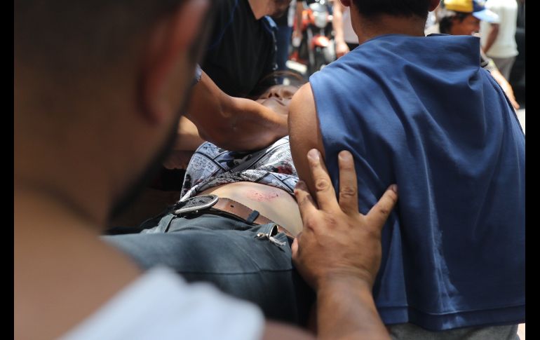 Simpatizantes de Juan Guaidó llevan a una mujer herida de bala en el estómago durante una manifestación a la altura del ministerio de Transporte en Caracas.