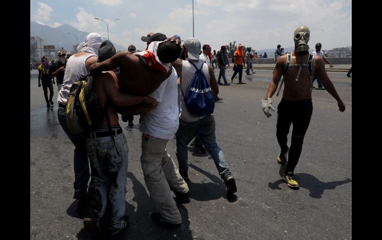 Un grupo de personas cargan un manifestante herido.