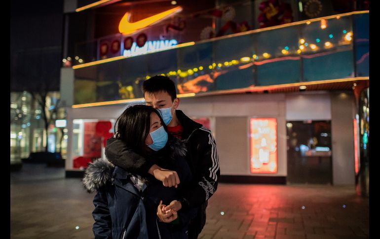 Una pareja se besa en una plaza comercial del área de Sanlitun. AFP/N. Asfouri