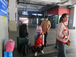 Una familia espera su tren en una estación de tren en Yichang, provincia de Hubei. EFE/L. Junfeng